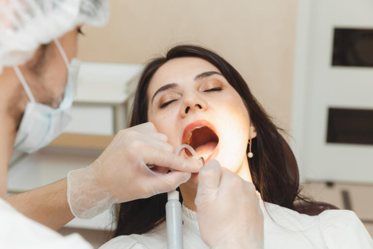 Dentist examining patient’s gums during a periodontal disease treatment and gum health evaluation.