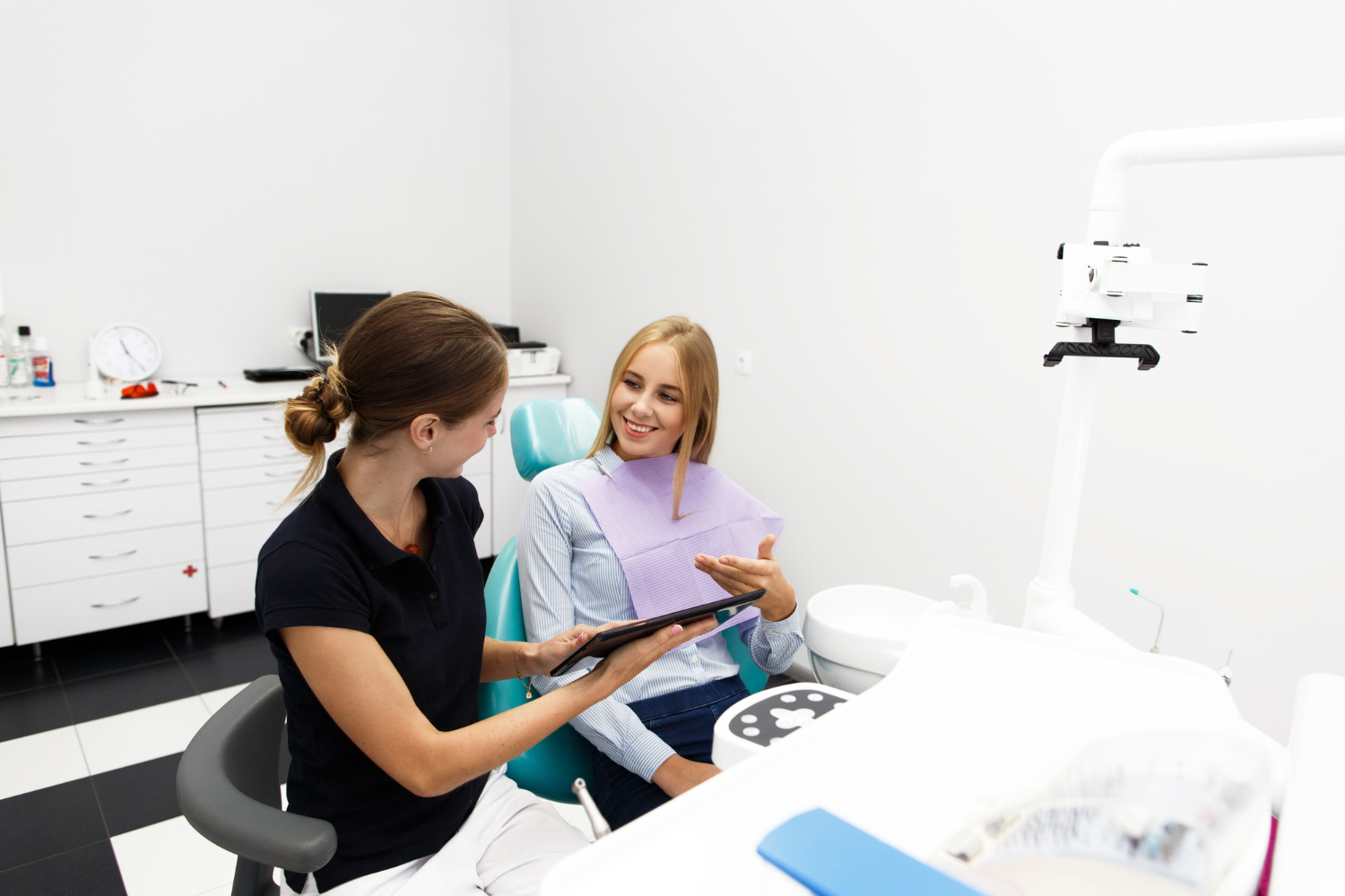 Periodontist discussing laser periodontal therapy and treatment options with a patient during a dental consultation now.