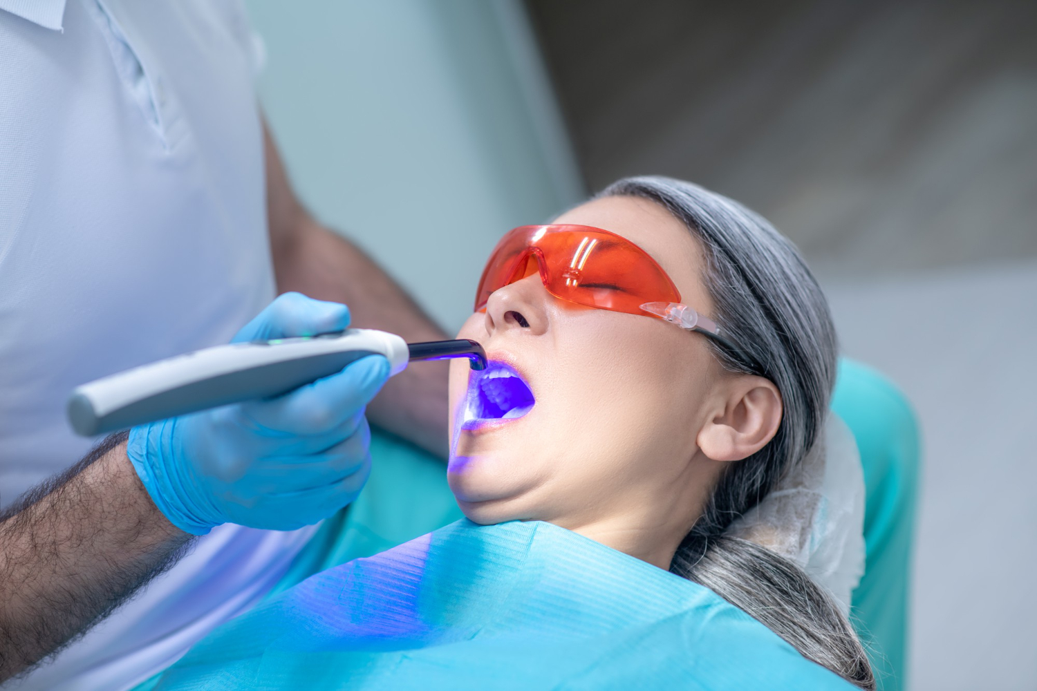 Periodontal disease treatment with a dentist performing a dental procedure on a patient’s teeth.